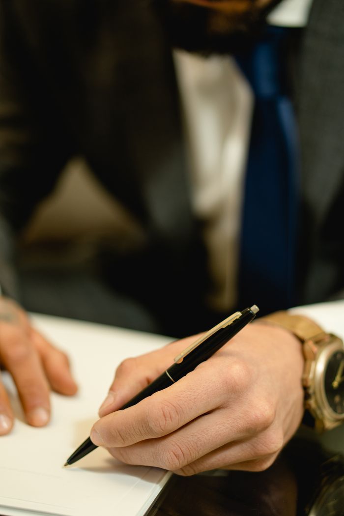 services-01 Close-up of hand signing a legal contract with a pen. Ideal for business and legal themes.