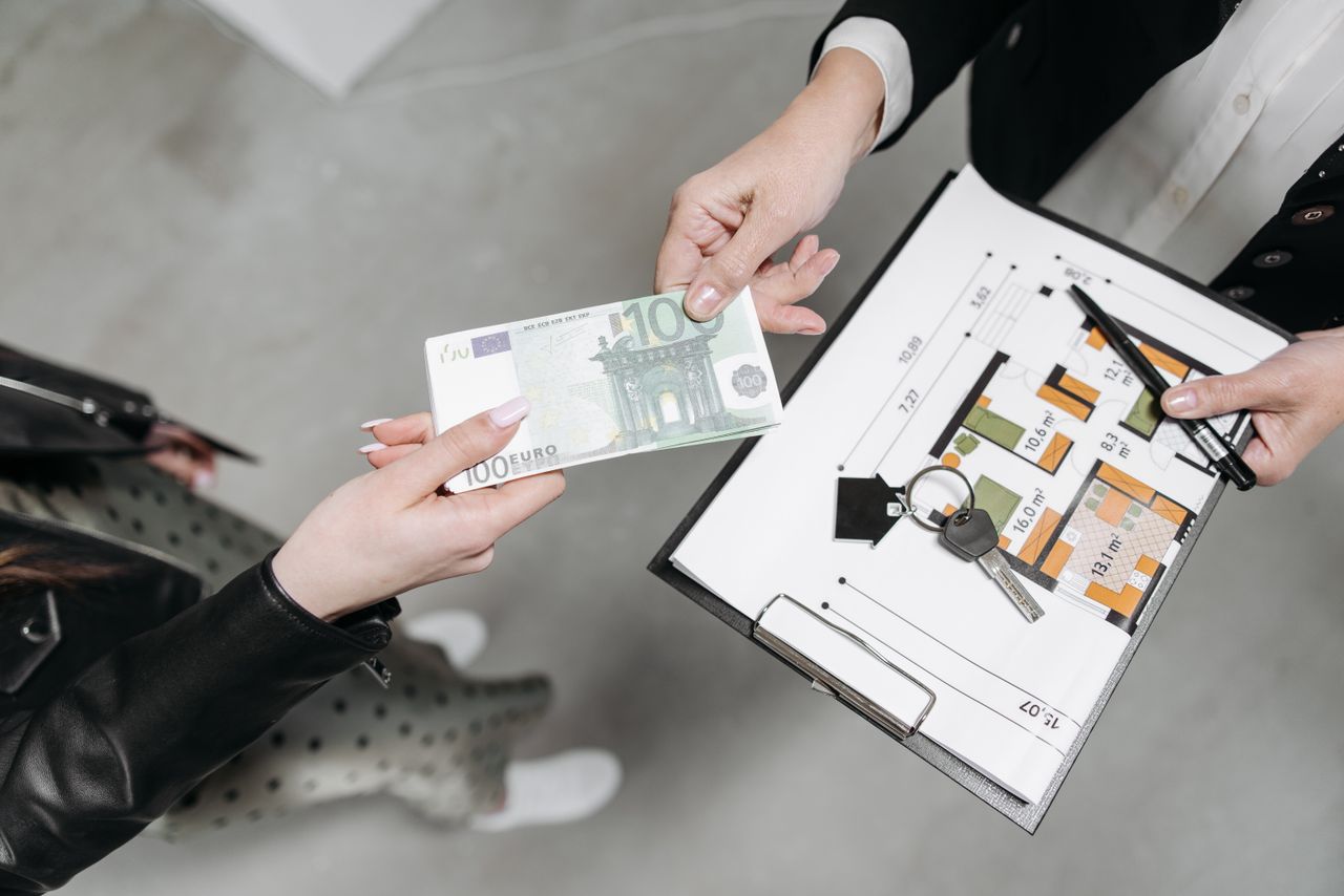 featured-images-04 Close-up of a real estate transaction with euro bill, keys, and floor plan.
