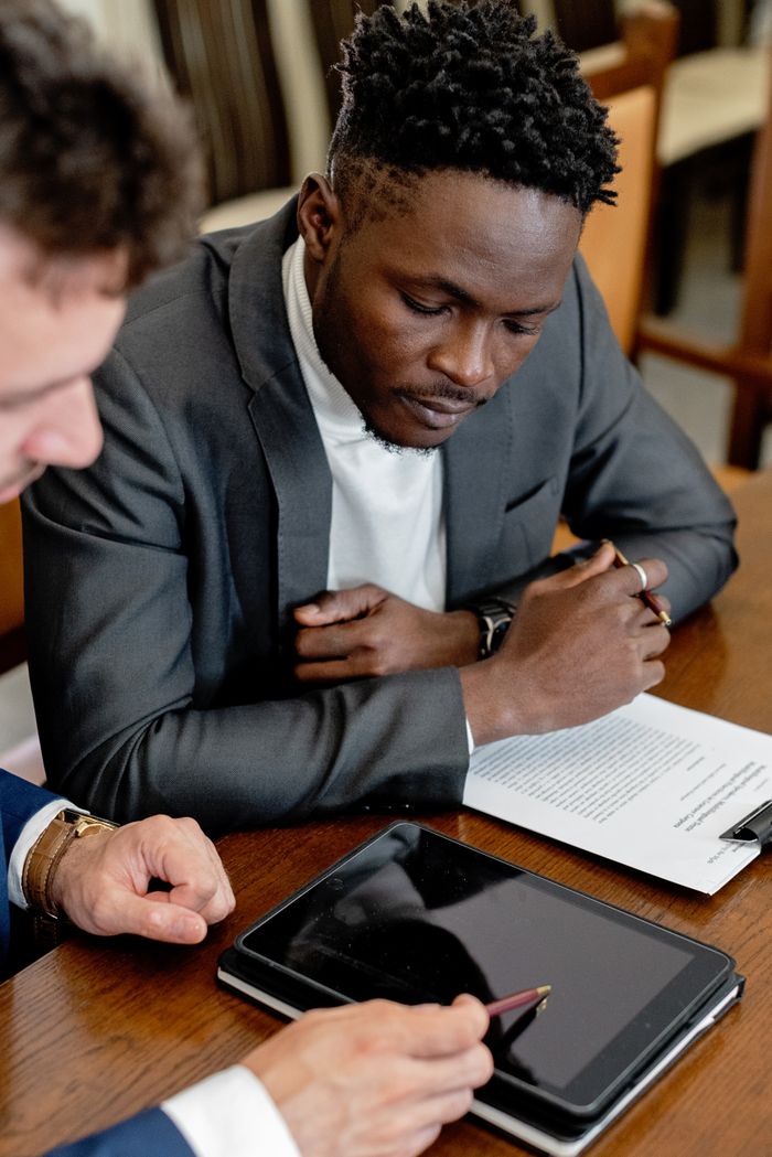 services-03 Professionals reviewing legal documents and using a tablet in a formal business setting.
